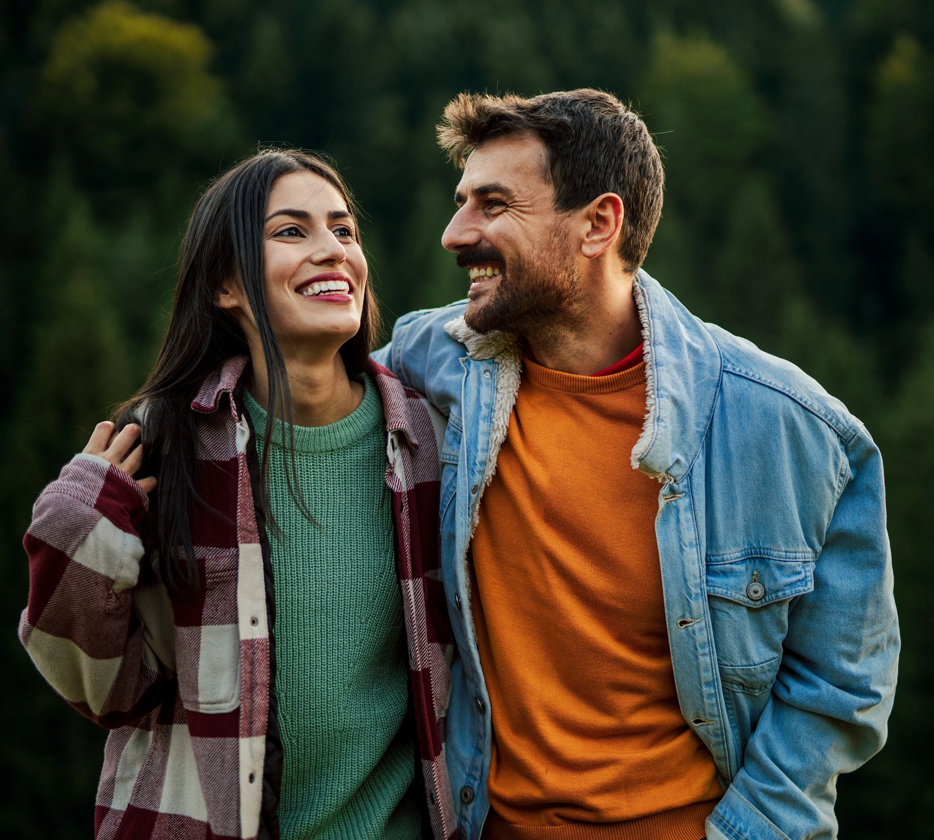 Casal sorrindo em imagem institucional da Pluna, nova marca de seguros da Bancorbrás.